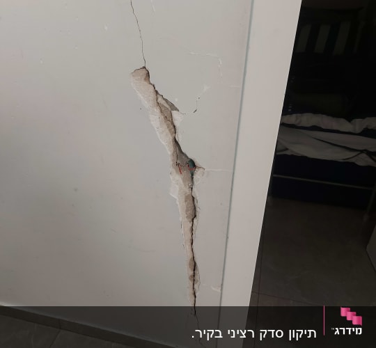 קיר עם סדק גדול וחשיפת טיח
